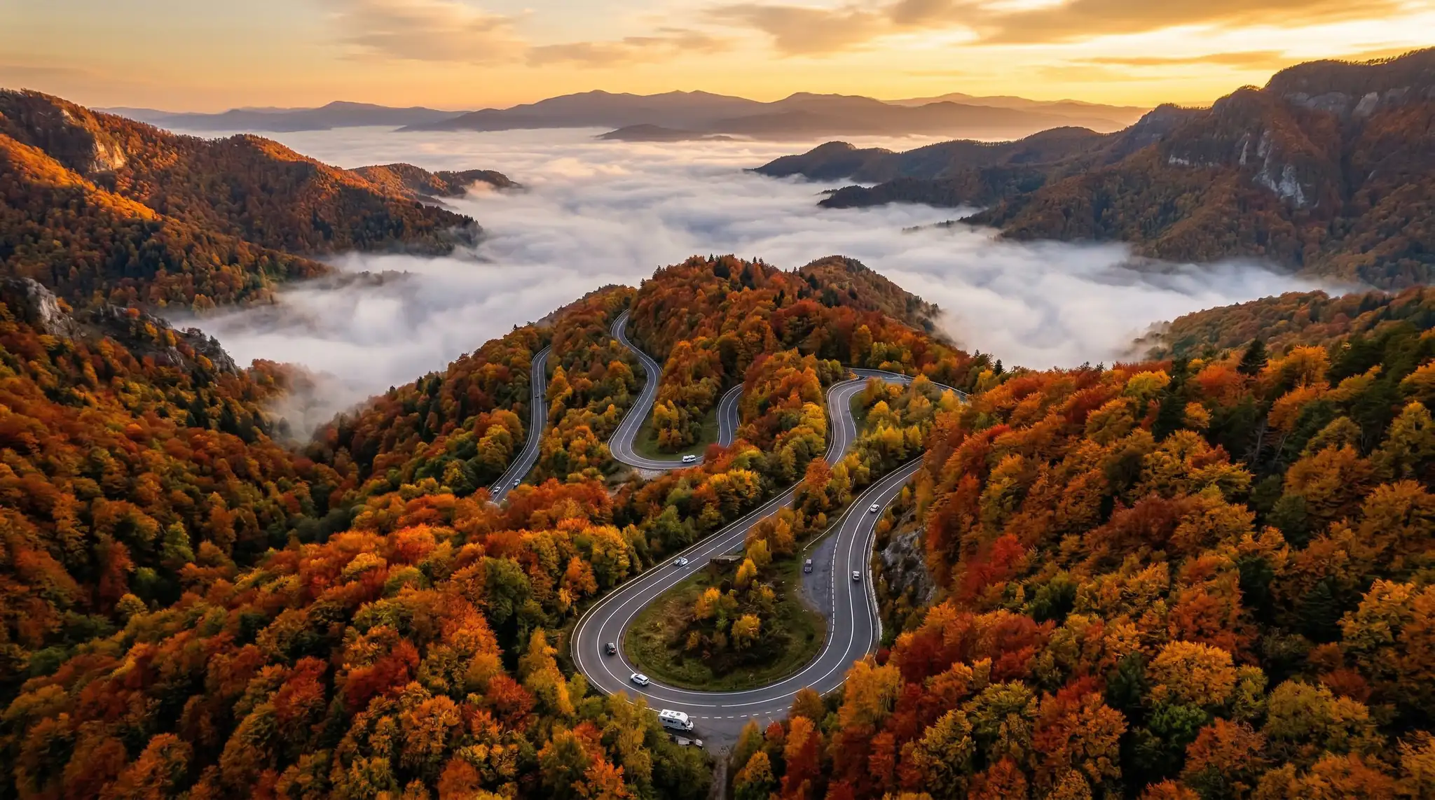 AI Prompts for Drone-Style Aerial Videos 5 Aerial view of winding mountain road through autumn forest with fog in valleys